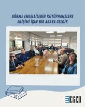 Toplantı masasında oturan kadın ve erkeklerden oluşan bir grup insan. Masanın üzerinde çeşitli küçük eşyalar, bir Türk bayrağı ve cam bir sürahi var. Katılımcıların bazıları görme engelli, bunu gözlüklerinden ve beyaz bastonlarından anlamak mümkün. Odanın duvarlarında pencereler, fotoğraflar ve bir harita bulunuyor. Görselin üst kısmında büyük puntolarla "Görme Engellilerin Kütüphanelere Erişimi İçin Bir Araya Geldik" yazıyor. Alt köşede ise üç kitap çizimi ve "EGED" logosu görülüyor.